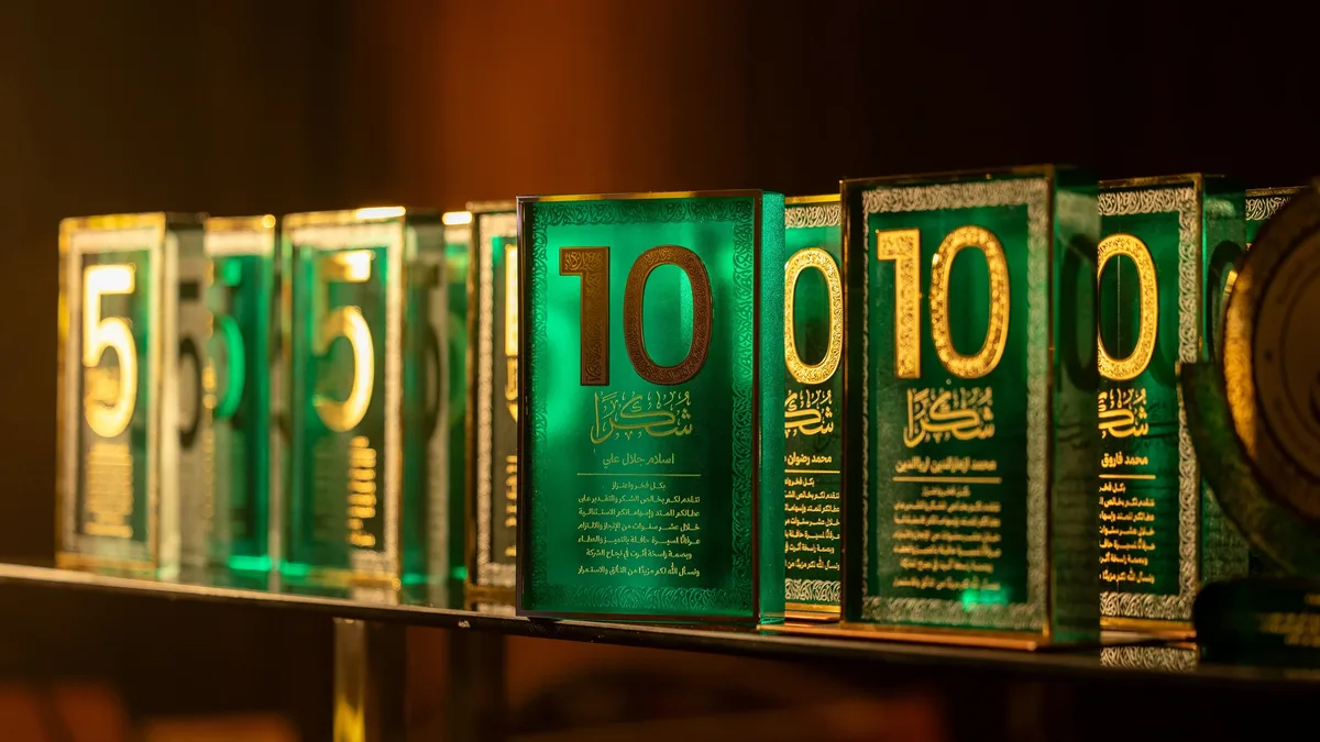 A row of green and gold awards on a shelf.